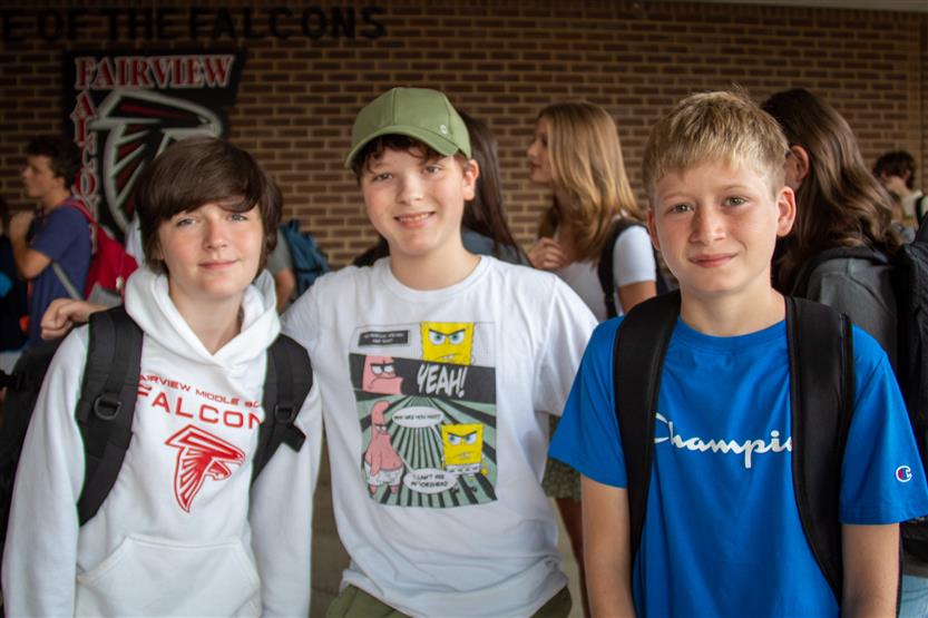 Three students smile